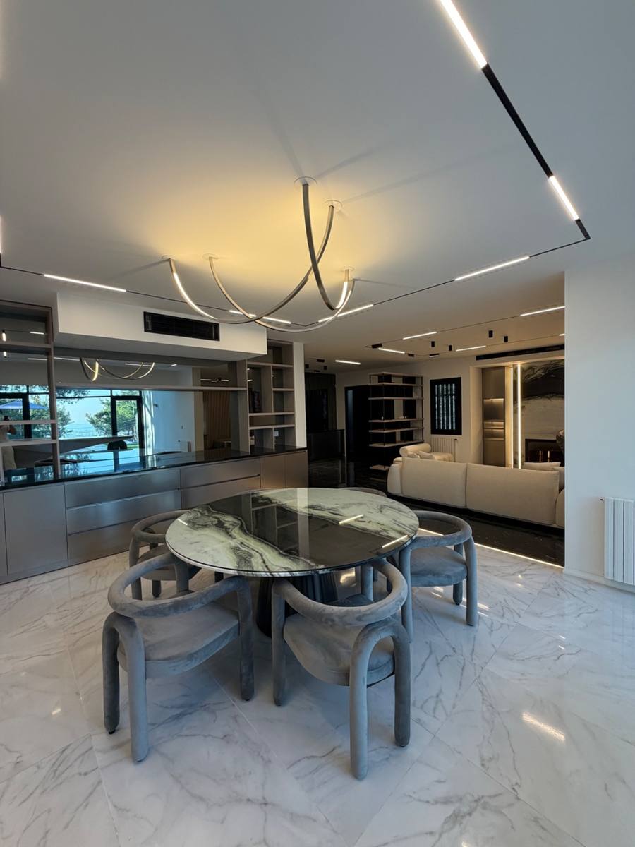 Completed living space of the private villa in Adma — marble floor, sculpted stone table, linear lighting
